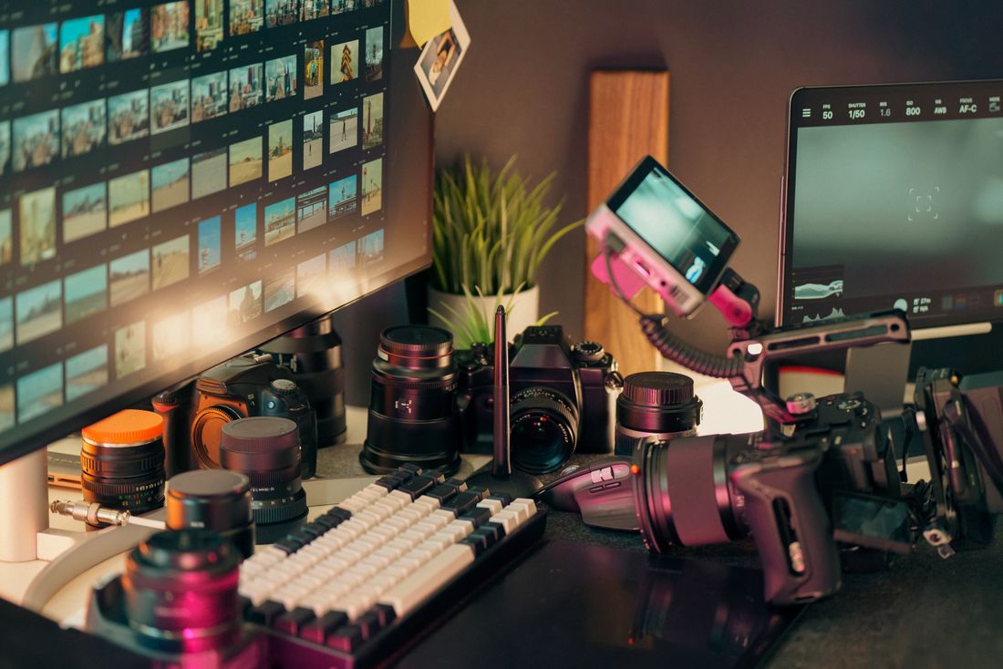 Cameras, lenses and monitors in a video editing workspace.