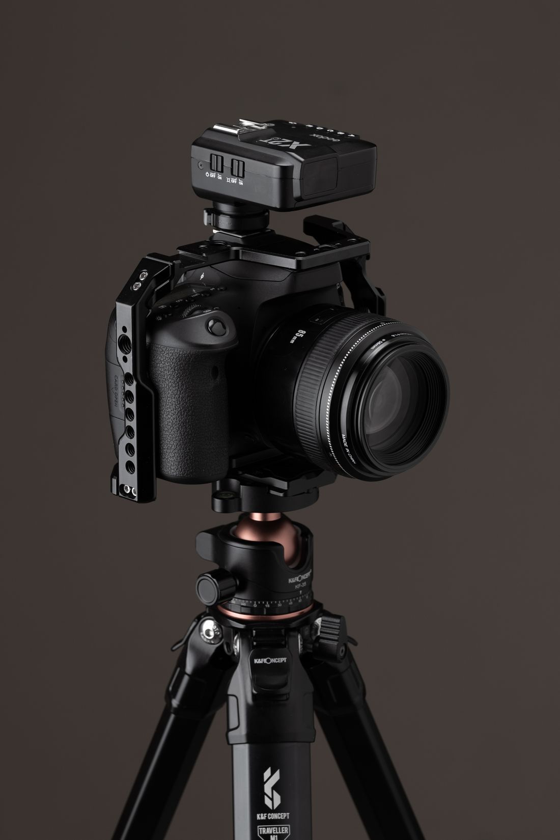 A digital camera supported by a studio tripod.
